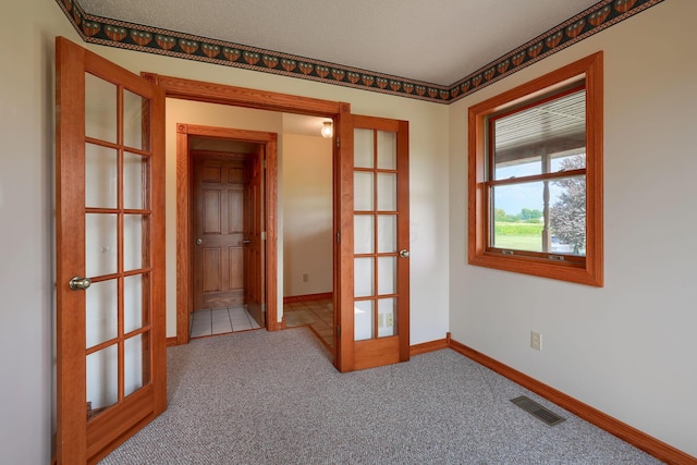 carpeted spare room with french doors