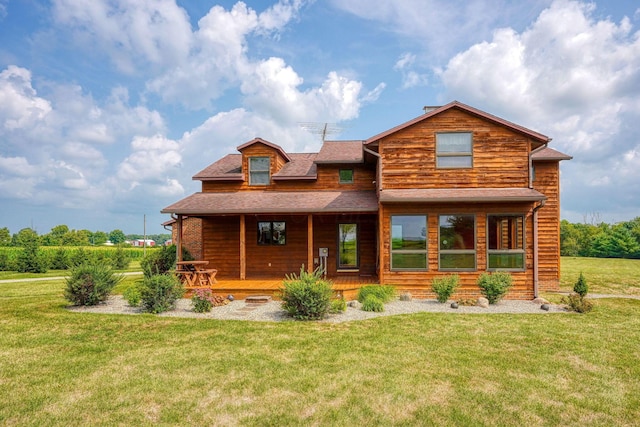 rear view of property featuring covered porch and a yard