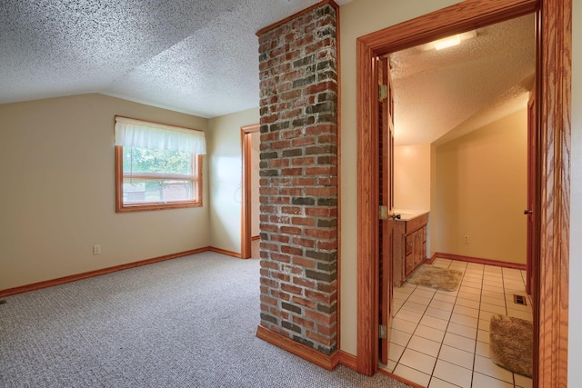 hallway featuring light carpet, a textured ceiling, and lofted ceiling