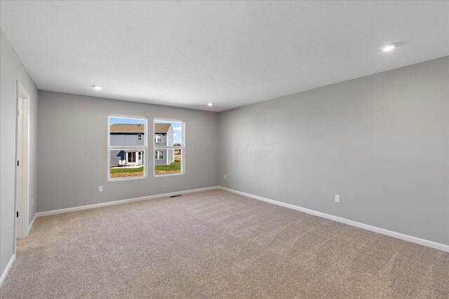 carpeted spare room with a textured ceiling