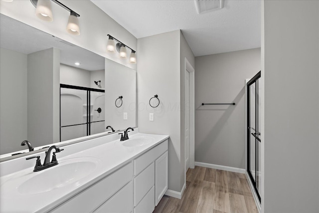 bathroom with vanity, hardwood / wood-style flooring, and an enclosed shower