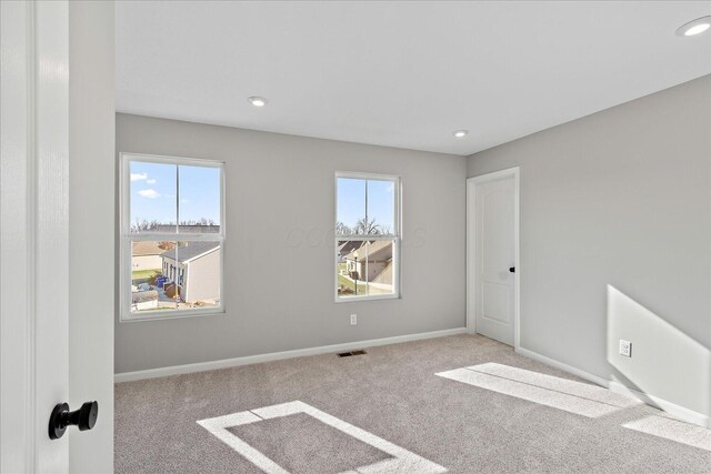 spare room with plenty of natural light and light carpet