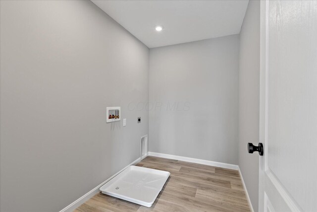 clothes washing area featuring hookup for an electric dryer, washer hookup, and light hardwood / wood-style flooring