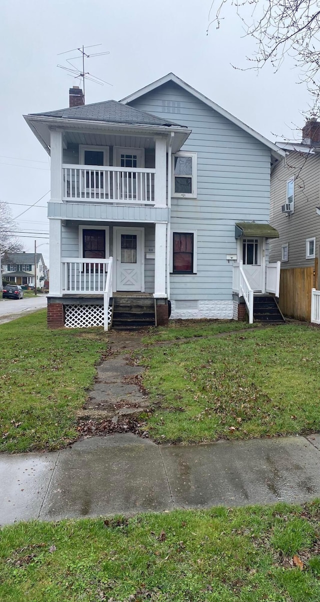 view of front of home with a front yard and a balcony