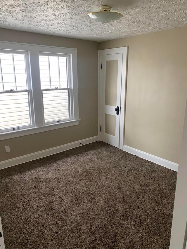 spare room with a textured ceiling and carpet floors