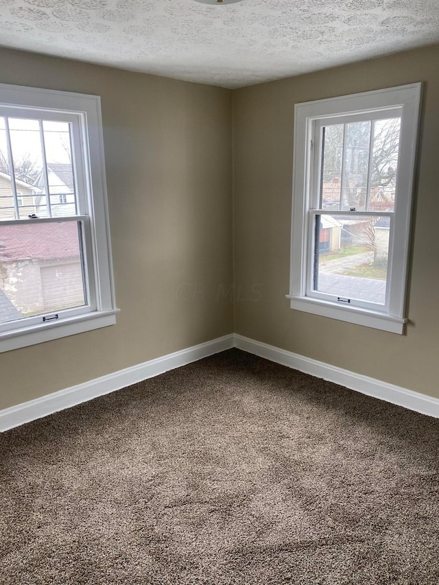 carpeted spare room with a textured ceiling