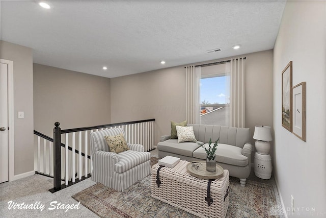 carpeted living room featuring a textured ceiling