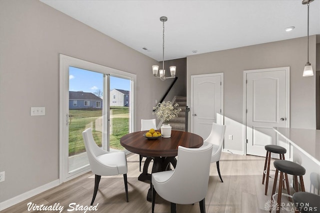 dining space featuring light hardwood / wood-style flooring and an inviting chandelier