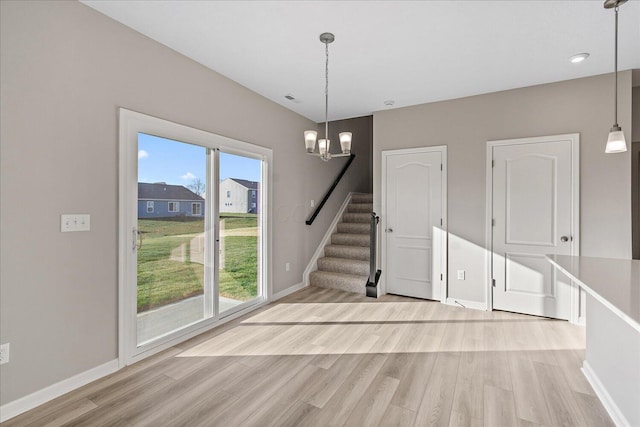 interior space featuring a chandelier, a healthy amount of sunlight, and light wood-type flooring