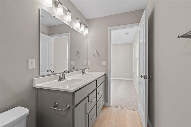 bathroom featuring toilet, vanity, and hardwood / wood-style flooring