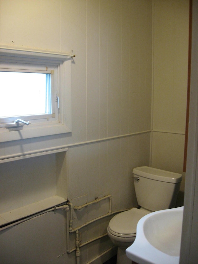 bathroom featuring sink, tile walls, and toilet