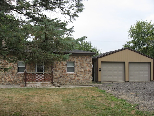 view of front of home featuring an outbuilding, a garage, and a front lawn