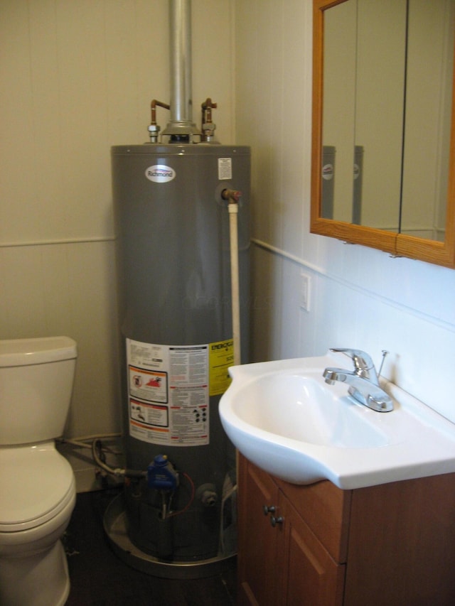 bathroom featuring vanity, toilet, and gas water heater