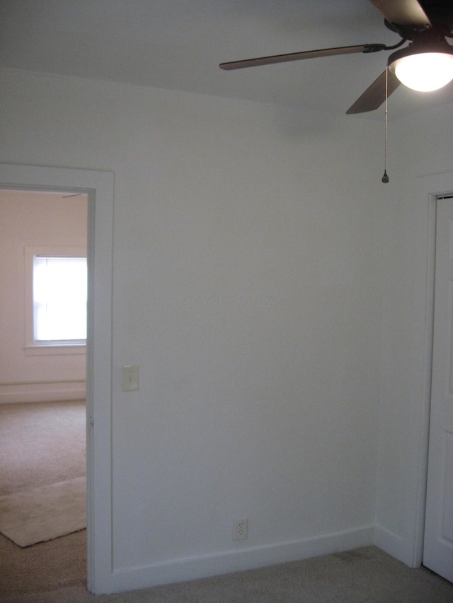 carpeted empty room featuring ceiling fan