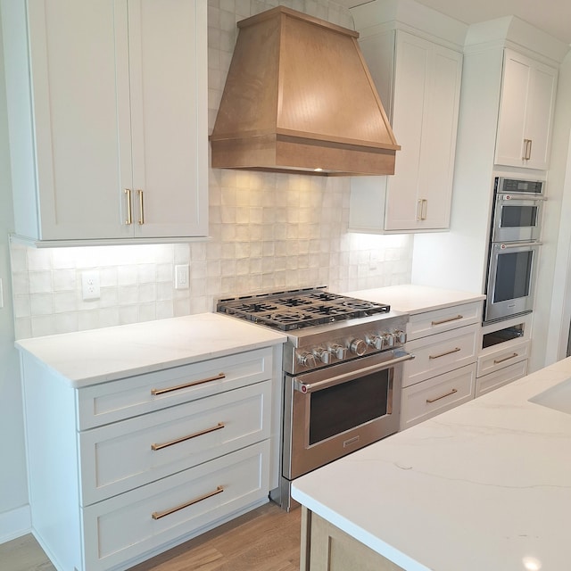 kitchen with white cabinetry, light hardwood / wood-style flooring, decorative backsplash, appliances with stainless steel finishes, and custom exhaust hood