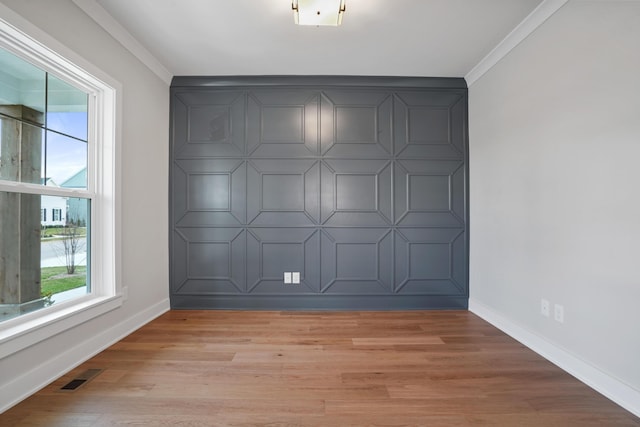 unfurnished room featuring light hardwood / wood-style floors and crown molding