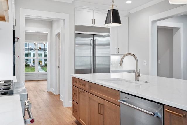 kitchen featuring white cabinetry, sink, light hardwood / wood-style floors, and appliances with stainless steel finishes