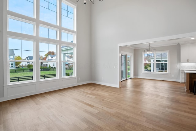 unfurnished living room featuring a chandelier and a healthy amount of sunlight