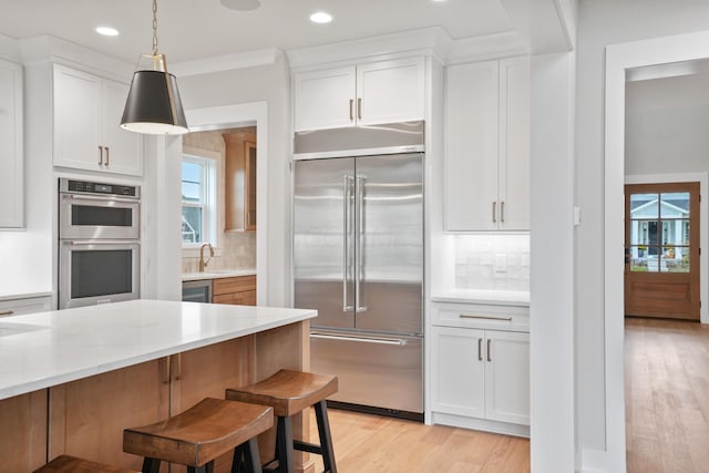 kitchen featuring decorative backsplash, white cabinetry, and stainless steel appliances