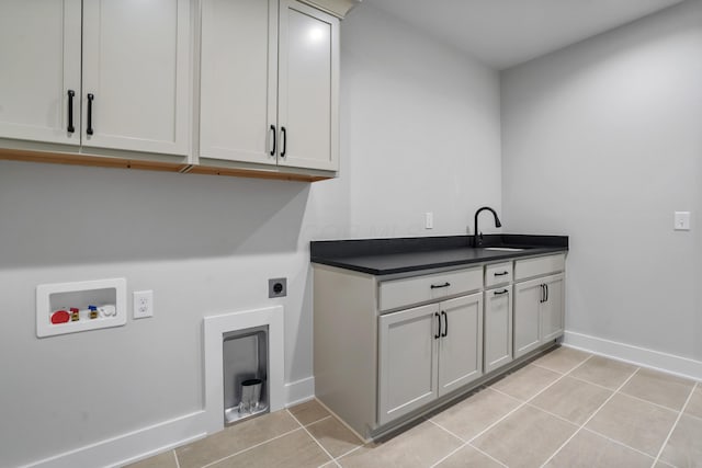 clothes washing area with sink, cabinets, washer hookup, hookup for an electric dryer, and light tile patterned floors