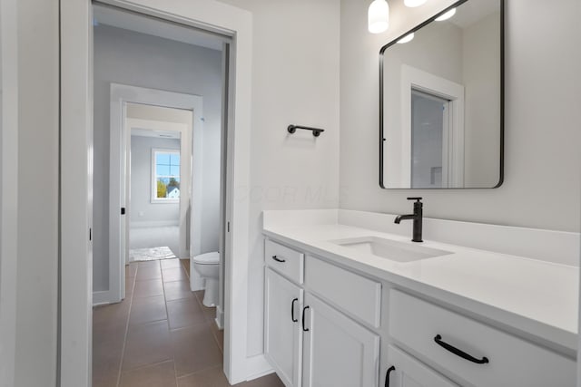 bathroom featuring tile patterned floors, vanity, and toilet