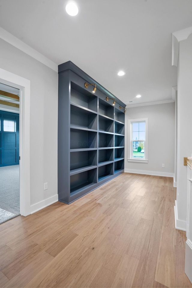 unfurnished living room featuring light wood-type flooring and ornamental molding