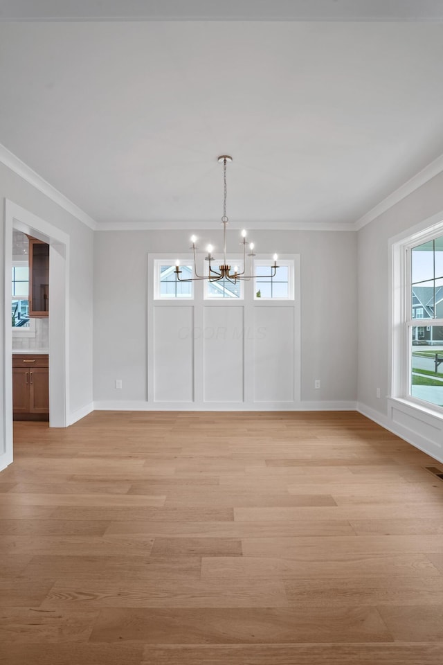 interior space featuring an inviting chandelier, light wood-type flooring, and ornamental molding