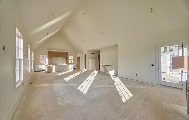 unfurnished living room with high vaulted ceiling