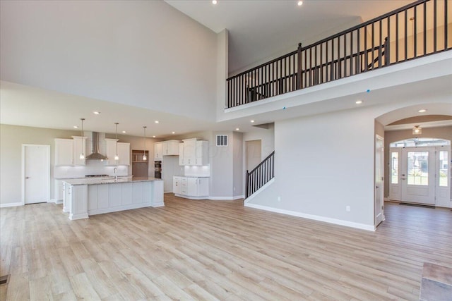 unfurnished living room with light hardwood / wood-style floors and a high ceiling