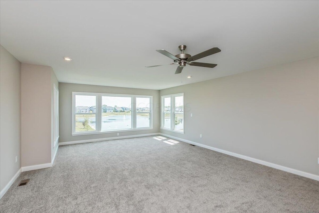 carpeted spare room with ceiling fan