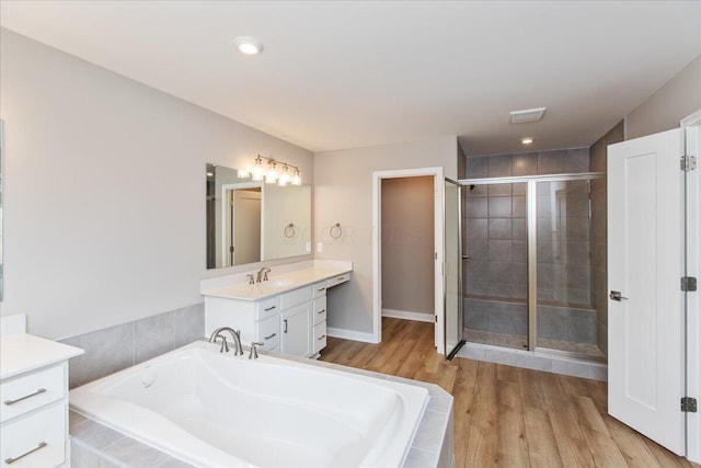 bathroom with plus walk in shower, vanity, and hardwood / wood-style flooring