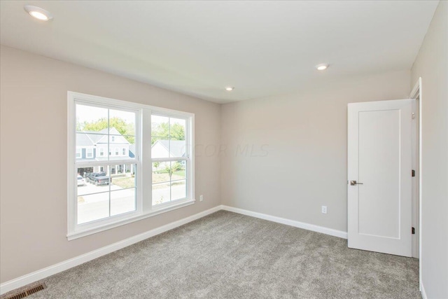 unfurnished room featuring light colored carpet