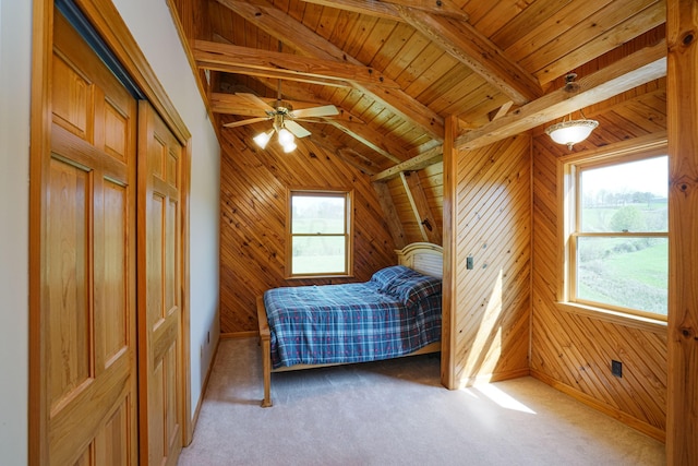 carpeted bedroom with ceiling fan, multiple windows, wooden walls, and wood ceiling