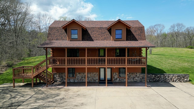 cabin with a front lawn, a patio, and a deck