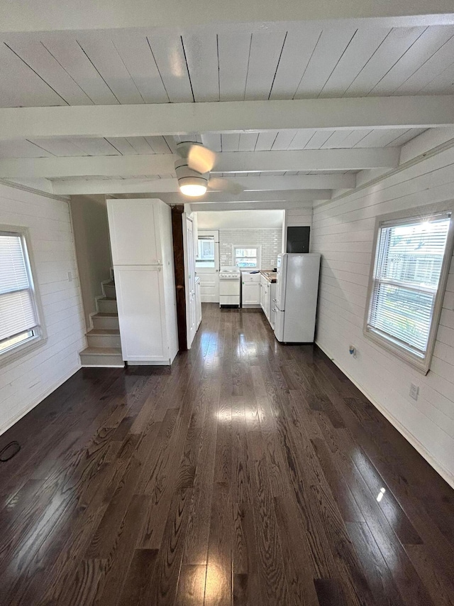 empty room featuring beam ceiling, wooden walls, dark hardwood / wood-style flooring, and wood ceiling