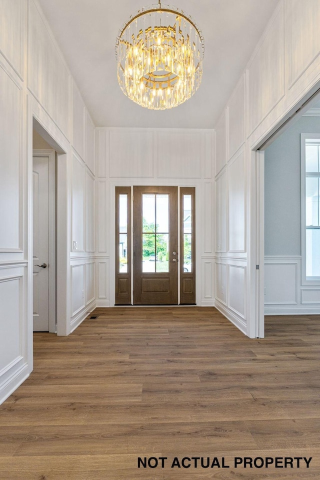 foyer with hardwood / wood-style floors and a chandelier