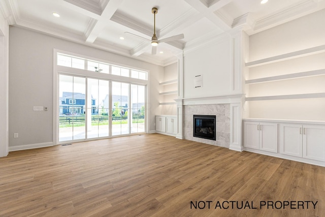 unfurnished living room with light wood-type flooring, crown molding, and a premium fireplace