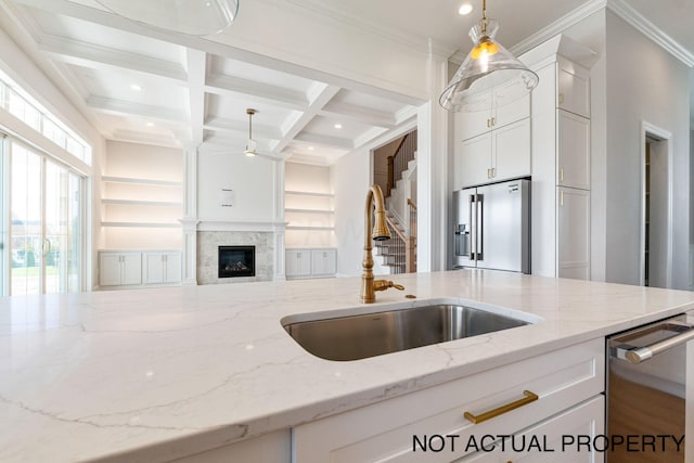 kitchen featuring light stone countertops, appliances with stainless steel finishes, white cabinetry, and sink