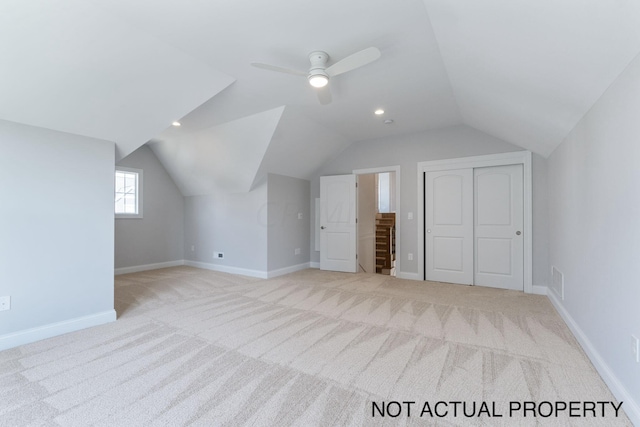 bonus room featuring ceiling fan, light colored carpet, and lofted ceiling