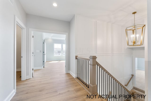 hallway featuring an inviting chandelier and light wood-type flooring