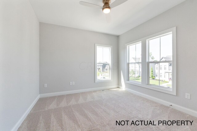 carpeted spare room featuring ceiling fan