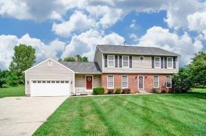 view of front of house with a garage and a front lawn