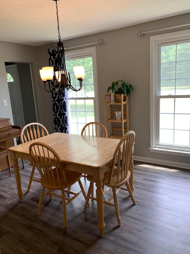 dining space featuring a chandelier, dark hardwood / wood-style floors, and a healthy amount of sunlight