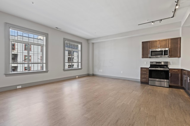 unfurnished living room featuring light wood-type flooring and track lighting