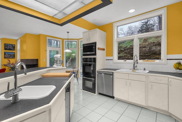 6730 Dublin Rd, Dublin, OH 43017 - kitchen featuring built in microwave, white cabinetry, sink, stainless steel dishwasher, and pendant lighting