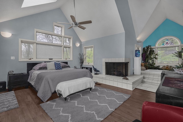 6730 Dublin Rd, Dublin, OH 43017 - bedroom featuring a skylight, ceiling fan, dark wood-type flooring, high vaulted ceiling, and a tiled fireplace