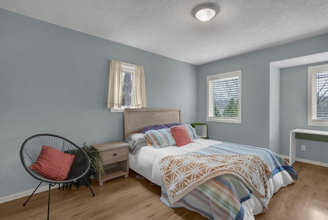 6730 Dublin Rd, Dublin, OH 43017 - bedroom with light hardwood / wood-style floors, a textured ceiling, and multiple windows