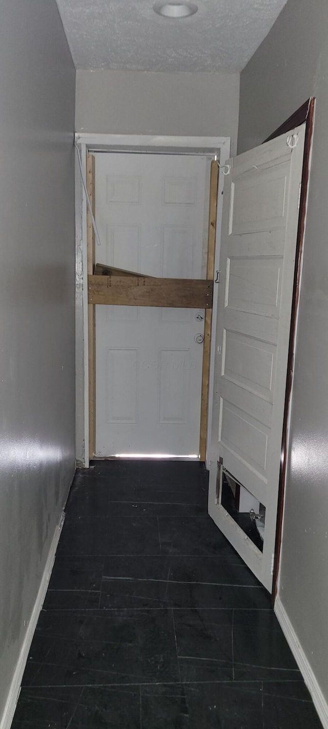 hallway with a textured ceiling