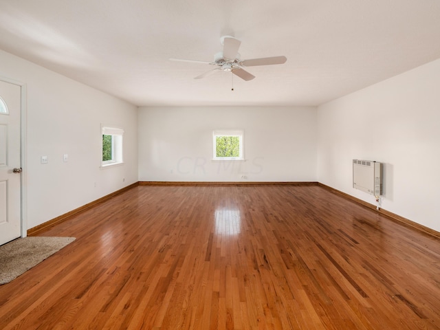 unfurnished room with heating unit, ceiling fan, and hardwood / wood-style flooring