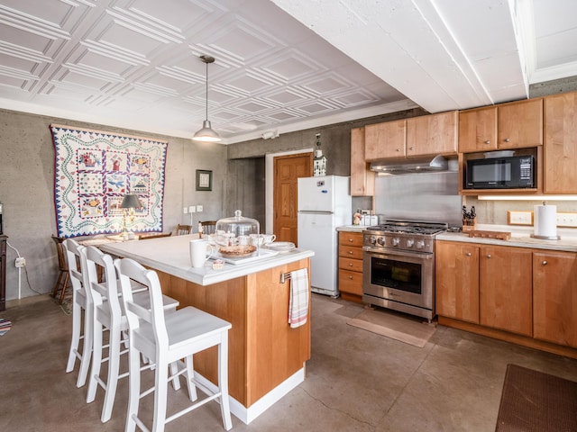 kitchen with high end range, black microwave, white refrigerator, decorative light fixtures, and a center island